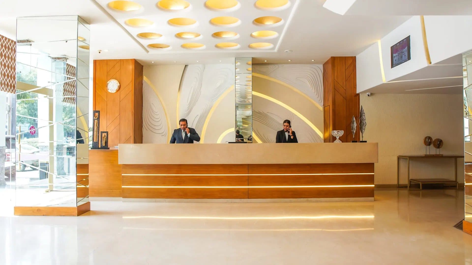 The reception desk and lobby of Hotel Centre Point, Nagpur, with the front-office team at work.