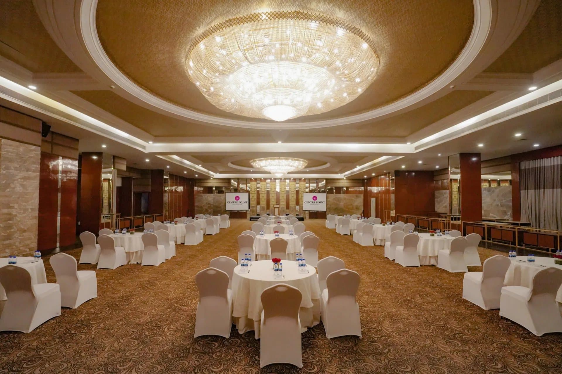 Palacio at Hotel Centre Point, set with round tables beneath a crystal chandelier.